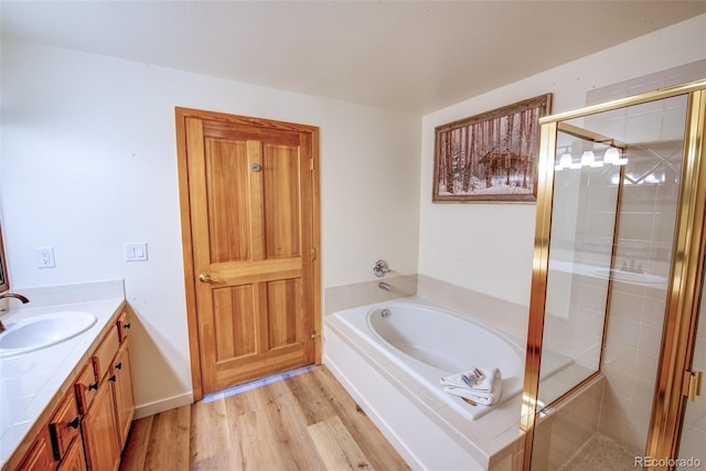 23110 US Highway 6 Unit 5040, Keystone, CO 80435 - bathroom featuring vanity, a bath, a shower stall, and wood finished floors