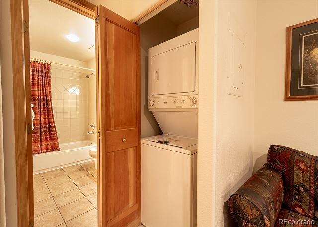 23110 US Highway 6 Unit 5040, Keystone, CO 80435 - laundry room featuring stacked washer and clothes dryer and light tile patterned flooring