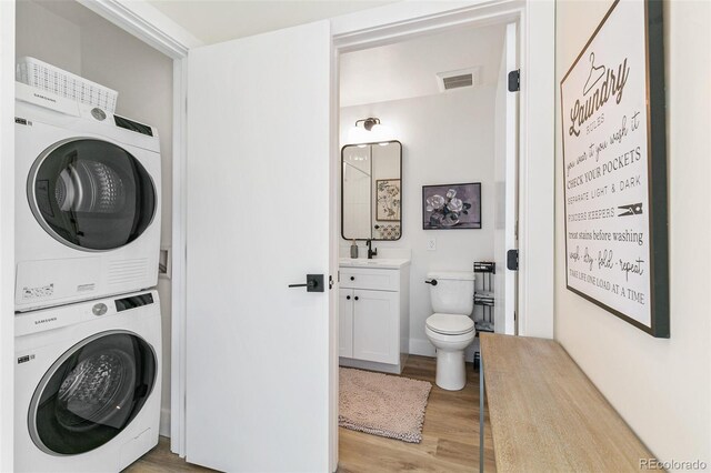 5363 W 14th Ave, Lakewood, CO 80214 - laundry area featuring stacked washer / dryer and light wood finished floors