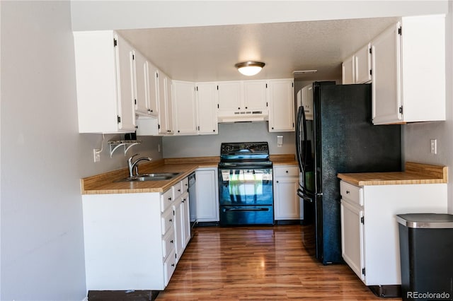 kitchen with sink, dark hardwood / wood-style flooring, white cabinetry, and black appliances