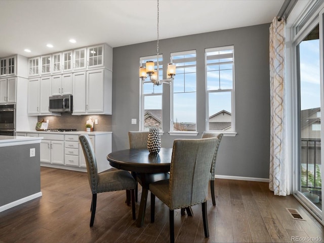 dining room with recessed lighting, baseboards, dark wood finished floors, an inviting chandelier, and visible vents