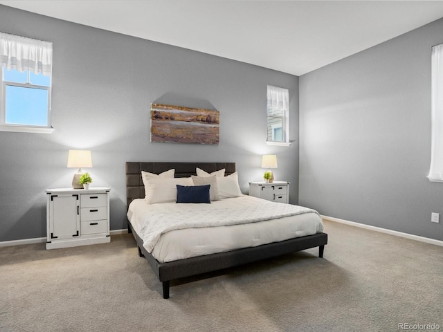 bedroom featuring light carpet, baseboards, and multiple windows