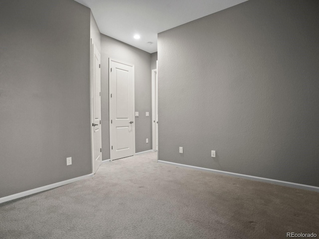 carpeted empty room with baseboards and recessed lighting