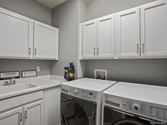 washroom featuring cabinet space, washer and clothes dryer, and a sink