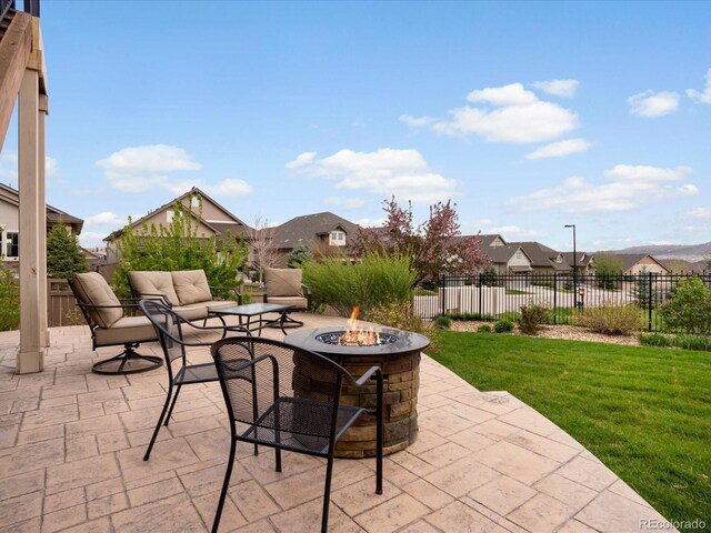 view of patio / terrace with fence, a fire pit, and a residential view