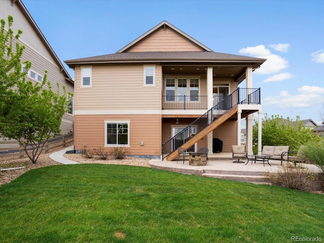back of house with stairway, a patio, a fire pit, and a yard