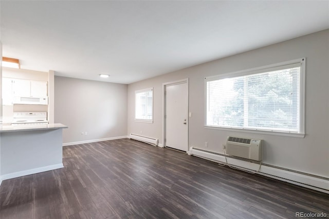 5770 E Warren Ave Unit 206, Denver, CO 80222 - unfurnished living room featuring baseboard heating, dark wood-style floors, a baseboard radiator, and a wall unit AC