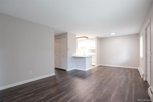 5770 E Warren Ave Unit 206, Denver, CO 80222 - unfurnished living room with baseboard heating and dark wood-type flooring