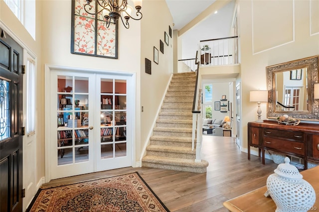 2061 Chesapeake Pl, Highlands Ranch, CO 80126 - foyer entrance featuring a high ceiling, stairs, wood finished floors, a chandelier, and french doors