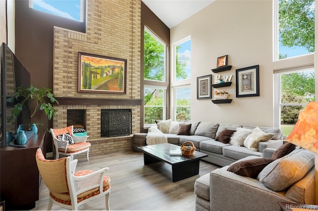 2061 Chesapeake Pl, Highlands Ranch, CO 80126 - living room with high vaulted ceiling, plenty of natural light, a brick fireplace, and wood finished floors