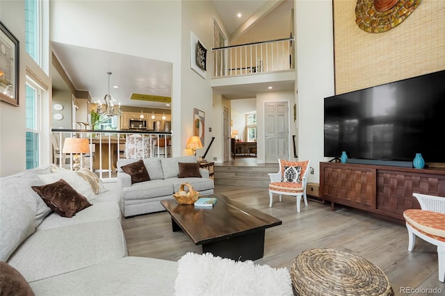 2061 Chesapeake Pl, Highlands Ranch, CO 80126 - living room featuring a towering ceiling, wood finished floors, plenty of natural light, and a chandelier