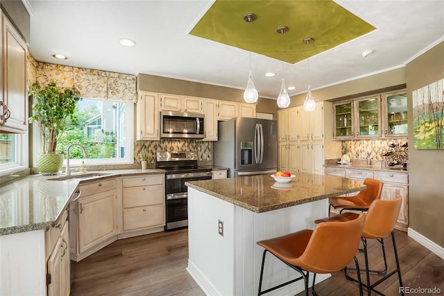 2061 Chesapeake Pl, Highlands Ranch, CO 80126 - kitchen featuring appliances with stainless steel finishes, a center island, decorative backsplash, dark stone countertops, and ornamental molding
