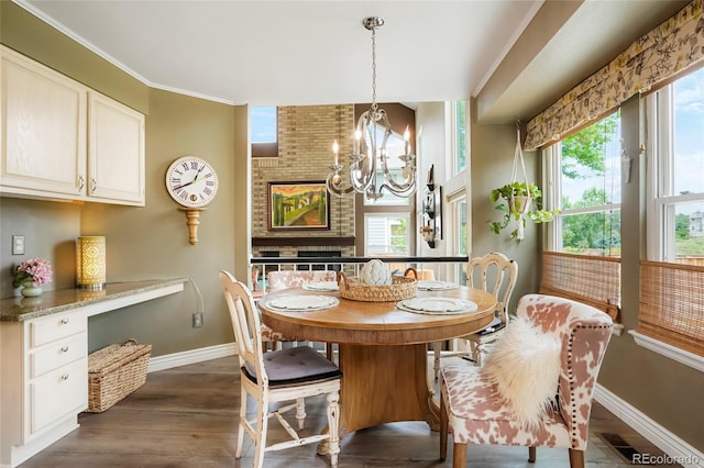 2061 Chesapeake Pl, Highlands Ranch, CO 80126 - dining area featuring a chandelier, dark wood-type flooring, plenty of natural light, and crown molding