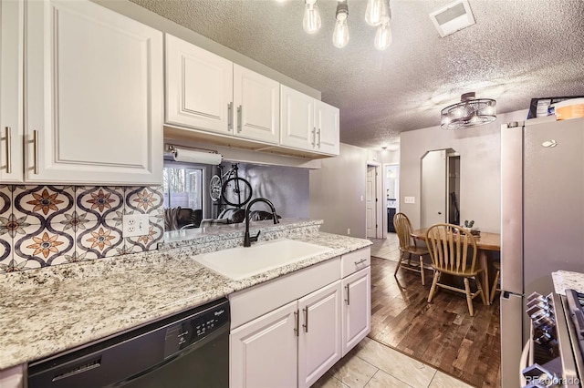 kitchen with visible vents, white cabinets, appliances with stainless steel finishes, a textured ceiling, and a sink