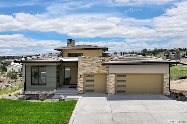 prairie-style house featuring a garage and a front lawn