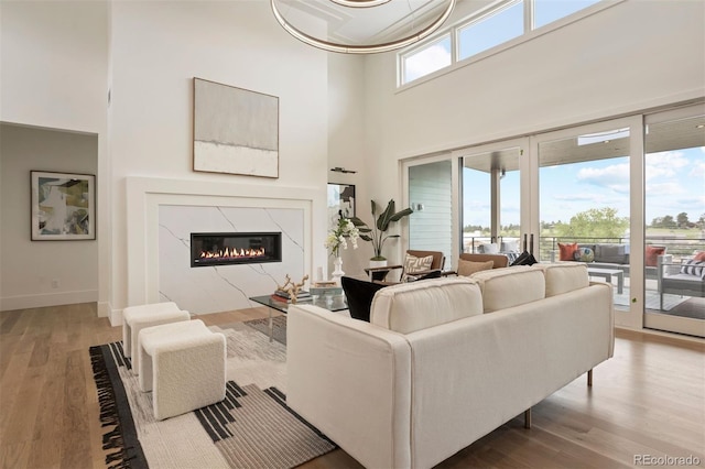 living room with a fireplace, hardwood / wood-style floors, and a high ceiling