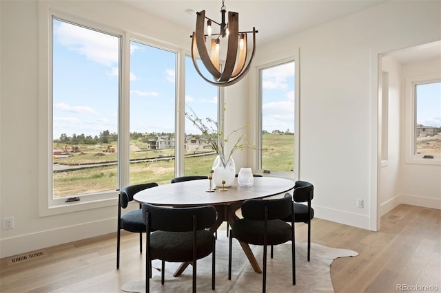 dining room with light hardwood / wood-style flooring and a chandelier