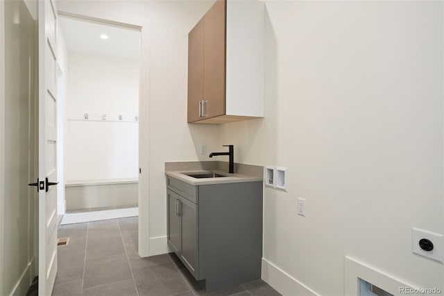 washroom with cabinets, washer hookup, electric dryer hookup, sink, and light tile patterned floors