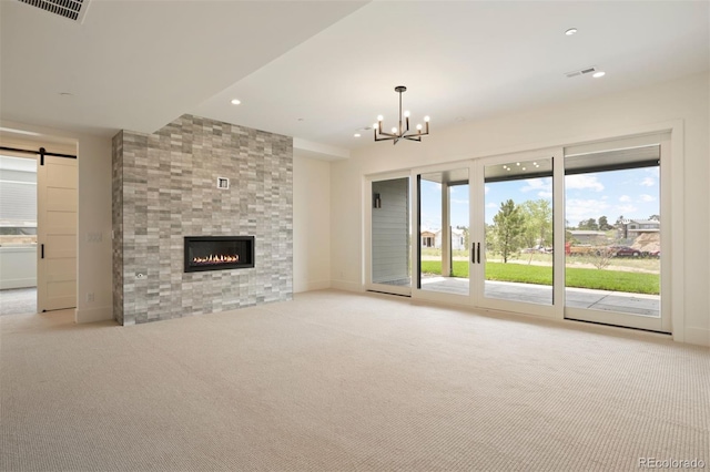 unfurnished living room featuring light colored carpet, a fireplace, and an inviting chandelier