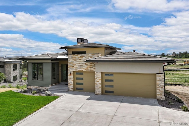 prairie-style home featuring a front yard and a garage