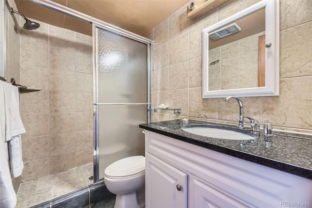 bathroom featuring toilet, an enclosed shower, vanity, and tile walls