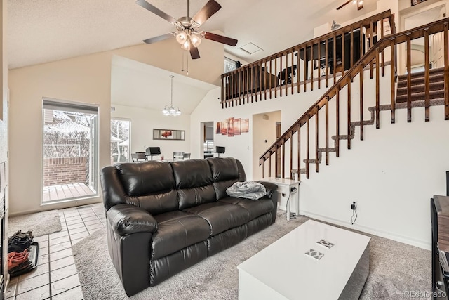 living area featuring light tile patterned floors, baseboards, stairs, high vaulted ceiling, and ceiling fan with notable chandelier