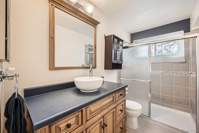 full bathroom with toilet, a shower stall, tile patterned flooring, and vanity