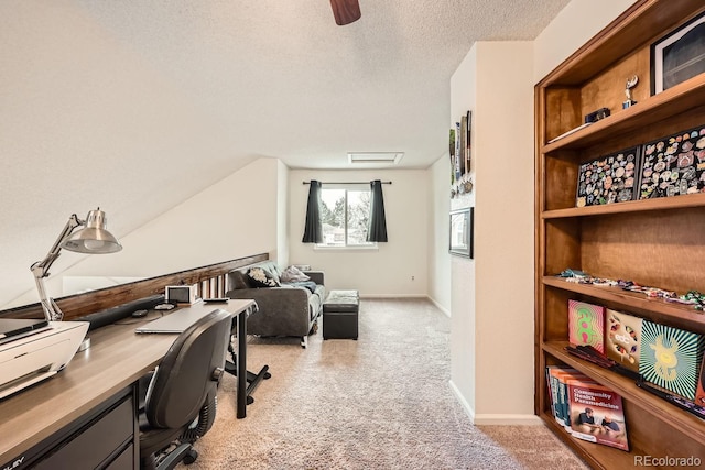 office space with light carpet, a textured ceiling, and baseboards