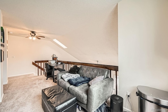 living room with carpet, lofted ceiling with skylight, a ceiling fan, a textured ceiling, and baseboards