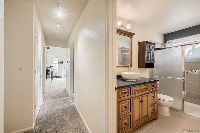 corridor featuring plenty of natural light, baseboards, a sink, and light colored carpet