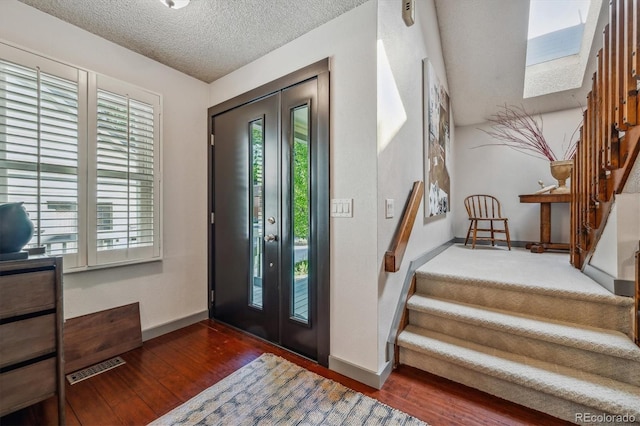 entrance foyer featuring a textured ceiling and dark wood-type flooring