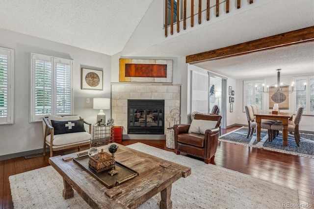 living room with a chandelier, a tile fireplace, a textured ceiling, and hardwood / wood-style floors