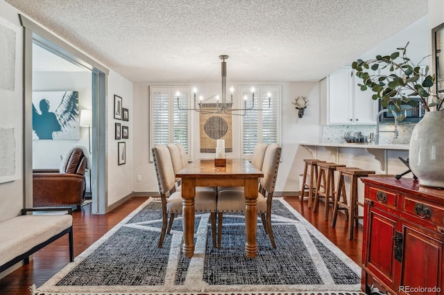 dining space featuring a textured ceiling, a chandelier, and dark hardwood / wood-style flooring