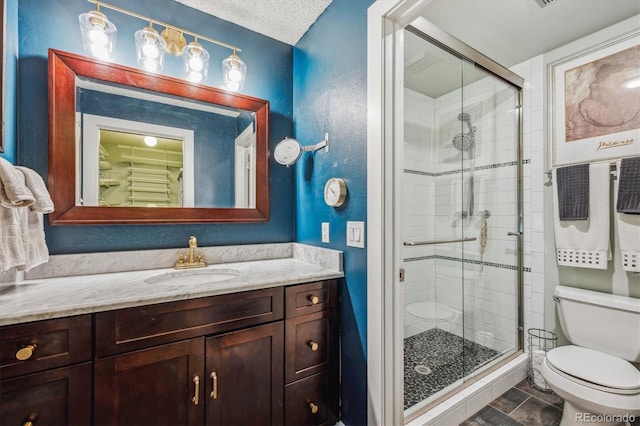 bathroom with toilet, vanity, tile patterned floors, a textured ceiling, and an enclosed shower