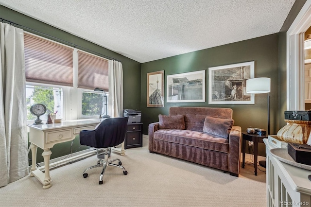 carpeted home office featuring a textured ceiling