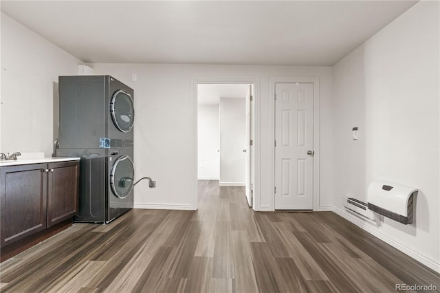 washroom with cabinets, dark hardwood / wood-style flooring, and stacked washing maching and dryer