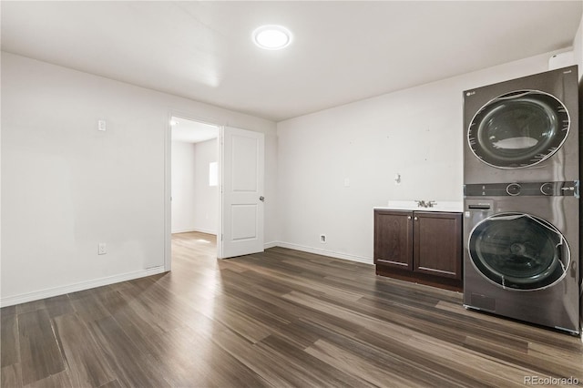 washroom with cabinets, dark hardwood / wood-style floors, and stacked washing maching and dryer