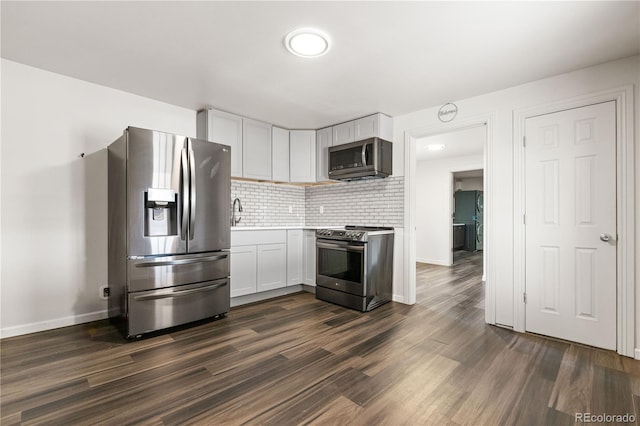 kitchen featuring sink, dark wood-type flooring, white cabinetry, stainless steel appliances, and decorative backsplash