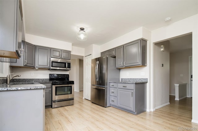 4760 S Wright Way, Morrison, CO 80465 - kitchen featuring appliances with stainless steel finishes, gray cabinets, light wood-style flooring, and light stone countertops