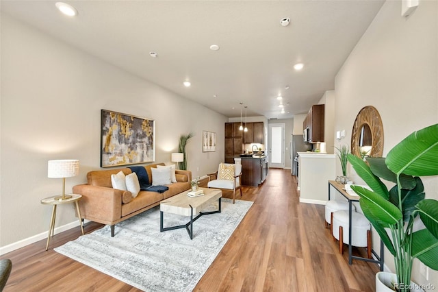 living room with recessed lighting, wood finished floors, and baseboards