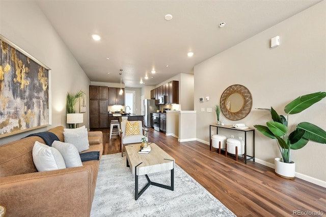 living area with dark wood-style floors, recessed lighting, and baseboards