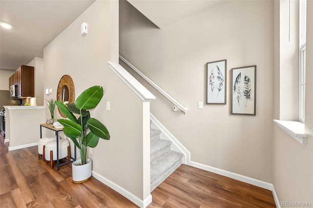 stairway featuring wood finished floors and baseboards