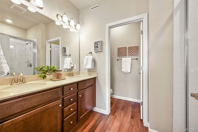 full bathroom featuring visible vents, a sink, toilet, and wood finished floors