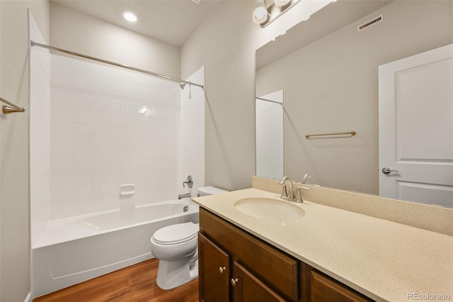 bathroom with bathing tub / shower combination, visible vents, toilet, vanity, and wood finished floors