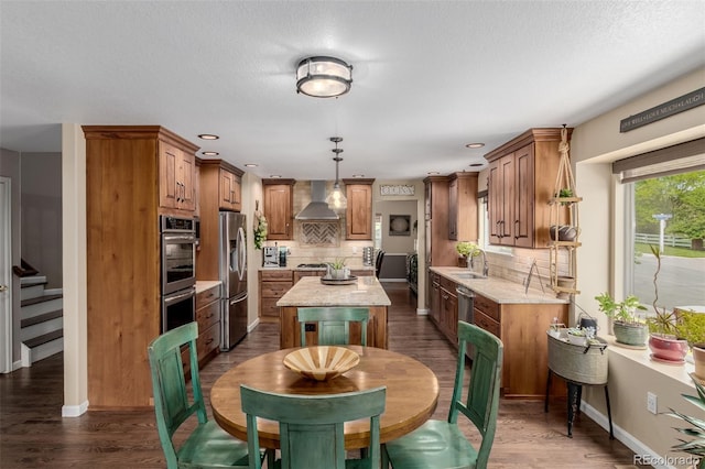 20182 E Maplewood Pl, Centennial, CO 80016 - kitchen with stainless steel appliances, wall chimney range hood, a kitchen island, decorative backsplash, and recessed lighting