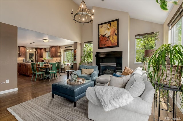 20182 E Maplewood Pl, Centennial, CO 80016 - living area featuring a chandelier, dark wood-style flooring, a glass covered fireplace, and high vaulted ceiling