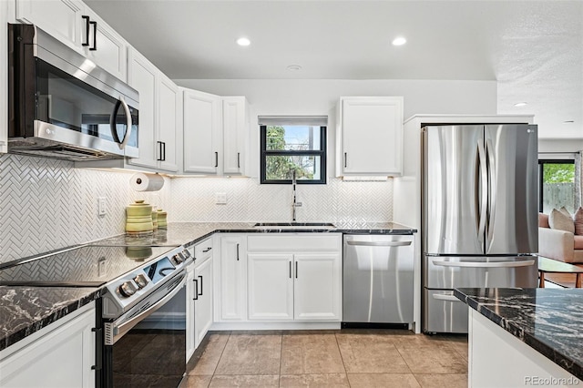 kitchen featuring stainless steel appliances, a sink, white cabinets, decorative backsplash, and recessed lighting