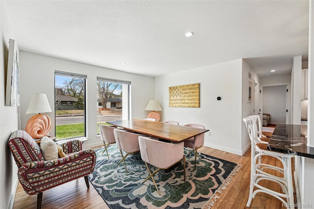 dining area with light wood-type flooring, recessed lighting, and baseboards