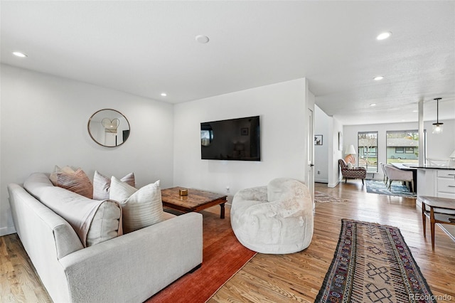 living room with recessed lighting, light wood-style floors, and baseboards
