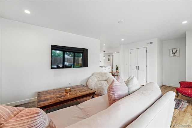 living room featuring baseboards, recessed lighting, and wood finished floors